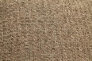Natural Linen Material Textile Canvas Fabric Texture Background Close-up Detail of Fabric Natural Color Hemp Material Pattern Design Wallpaper. Can be Used as Background or For Graphic Design photo