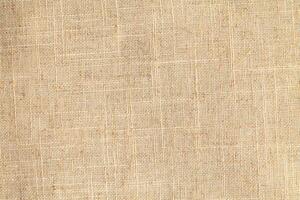 Natural Linen Material Textile Canvas Fabric Texture Background Close-up Detail of Fabric Natural Color Hemp Material Pattern Design Wallpaper. Can be Used as Background or For Graphic Design photo