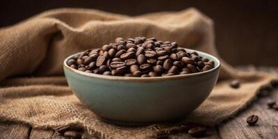 Bowl of coffee beans on rustic table with burlap sacks. photo