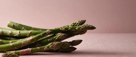 Fresh green asparagus on a pink background with copy space. photo
