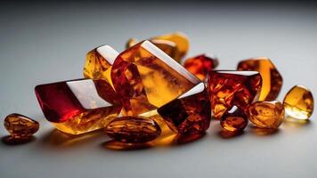 Red yellow polished amber pieces on white surface varying in size and transparency. photo