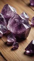 Large amethyst crystal cluster sparkling on natural wood surface. photo