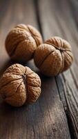 Three walnuts are displayed on a wooden table. photo