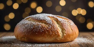 A close up of a bread roll with a sprinkle of powdered sugar on top. photo