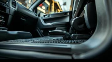 A view from inside the vehicle looking out highlighting the parking brake lever on the floor next to the drivers seat photo