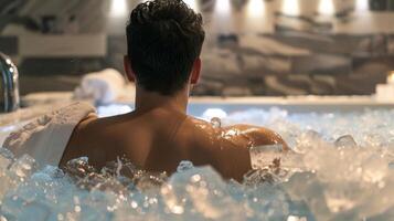 A client sitting in an ice bath with a towel wrapped around their shoulders for warmth photo