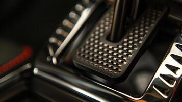 A closeup of a footoperated parking brake featuring a textured pedal and directional arrows for engaging and disengaging photo