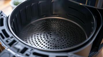 The interior of an air fryer displaying the nonstick coating and mesh bottom that helps achieve optimal air circulation for cooking photo