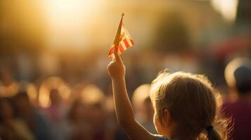 Closeup of a young childs hands eagerly waving a small flag with the parades symbol on it. photo