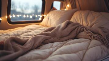 Closeup of a cozy and compact bed set up in the back of a van, surrounded by soft blankets and pillows. photo