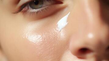 Closeup of a hand using a patting motion to apply eye cream onto the skin. photo