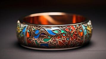 Closeup of a statement bracelet, featuring a wide cuff design with intricate etching and colorful enamel details. photo