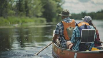 A couple sets off on a multiday canoe trip with a solar panel attached to the back of their boat to charge their devices as they paddle along photo