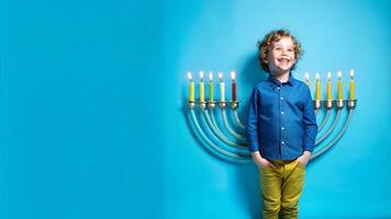 Portrait of boy with Hanukkah menorah on blue background photo