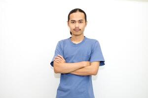 Smiling Asian man wearing dark blue t-shirt standing with arms crossed facing front. isolated in white background photo