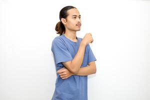 Smiling Asian man wearing dark blue t-shirt standing with arms almost touching chin facing sideways. isolated in white background photo