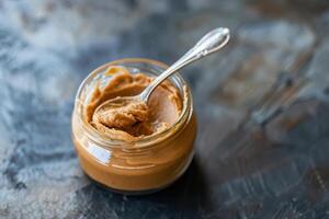 Peanut Paste in a Glass Jar with a Spoon photo