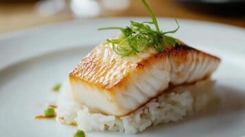 White plate with rice and smoked halibut served on top. photo