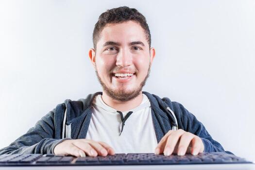 Portrait of nerdy man in front of keyboard. Smiling nerdy guy with hands on keyboard smiling at camera photo