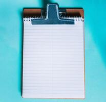 Top view of notepad on isolated background. Note book on clipboard on color background photo