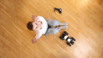 top view boy sitting on the floor, controls toy rc car with a remote control video