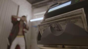 Machine that counts money and happy man. Footage. Rich man enjoys money. Man has received lot of money and is throwing it around video