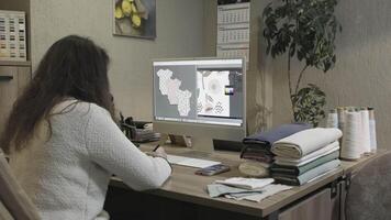 A Graphic Designer is utilizing digital design tools at their desk while working on a project video