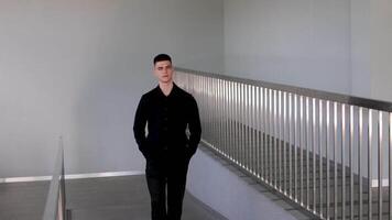businessman in a modern shiny corridor a guy is walking down the hallway with his hands in his pockets video