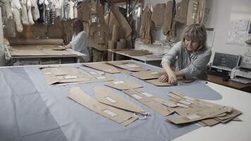 Tailors working on designing patterns and fabrics in a workshop with precision and skill video