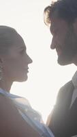 Posing of the newlyweds. Action.A beautiful young couple with a blonde girl in big earrings and her husband with a beard who are sitting and hugging on the street and the bright rays of the sun are video