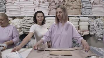 Women sorting and packing fabrics in a textile factory with dedication in an organized workplace video