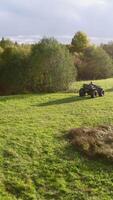 ATVs ride on green field. Clip. Top view of beautiful green field and riding ATVs. Quad bikes ride on green summer field on sunny day video