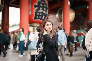 Tourist woman visit Sensoji Temple or Asakusa Kannon Temple is a Buddhist temple located in Asakusa, Tokyo Japan. Japanese sentence on red lantern means Thunder gate. photo