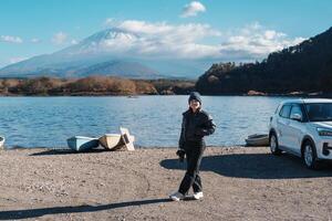 Woman tourist enjoy with Fuji Mountain at Lake Shoji, happy Traveler sightseeing Mount Fuji and road trip Fuji Five Lakes. Landmark for tourists attraction. Japan Travel, Destination and Vacation photo