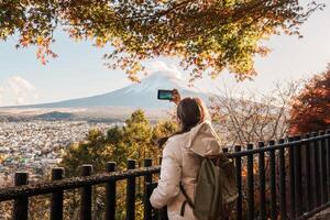 Woman tourist with mount Fuji at Chureito Pagoda in Autumn season, Traveler travel Arakurayama Sengen Park, Yamanashi, Japan. Landmark for tourist attraction. Japan Travel, Destination and Vacation photo