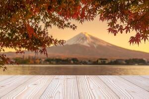 Empty wood table mockup with Mount Fuji view at Kawaguchiko lake background and copy space for text, Mock up for your product display and montage in autumn season. Japan travel and vacation concept photo
