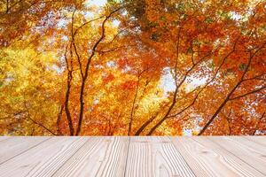 Empty wood table mockup on red maple leaves background in the garden with copy space for text, Mock up for your product display and montage in autumn season, thanksgiving and Halloween holiday concept photo