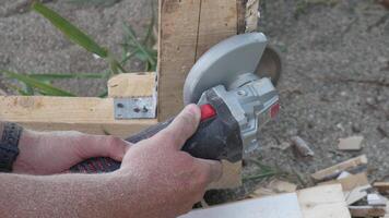 A man is using a power tool to cut wood. Concept of productivity and hard work. Slow motion video