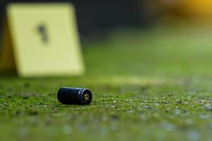 Bullet casings fall on cement floor and blurred background of evidence number sign at shooting scene. Concept of investigation, forensics, evidence, forensic science. photo