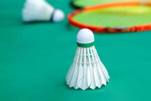 white shuttlecock on green background, blurred badminton racket and white shuttlecocks background. soft and selective focus. photo