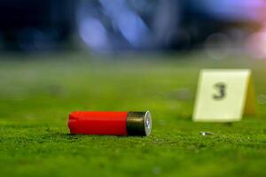 Bullet casings fell on the moss growing on the cement floor and blurry background of the evidence number plate at the scene and the car belonging to the culprit. Concept of investigation photo