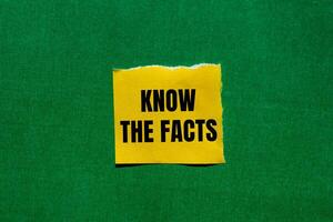 Know the facts message written on ripped torn yellow paper piece with green background. Conceptual know the facts symbol. Copy space. photo