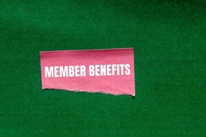 Member benefits message written on ripped torn pink paper piece on green background. Conceptual member benefits symbol. Copy space. photo