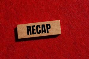 Recap word written on wooden block with red background. Conceptual recap word symbol. Copy space. photo