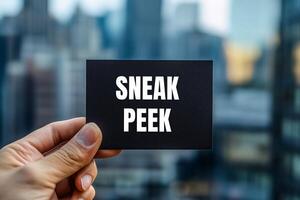 Sneak peek message written on black card with blurry modern city background. Conceptual sneak peek symbol. Copy space. photo