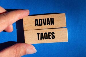 Advantages message written on wooden blocks with blue background. Conceptual advantages symbol. Copy space. photo