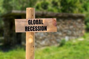 Global recession message written on wooden sign with nature background. Conceptual global recession symbol. Copy space. photo