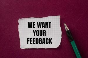 We want your feedback message written on ripped torn paper with a pen on purple background. Conceptual we want your feedback symbol. Copy space. photo