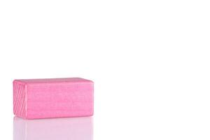Wooden cube of pink color on a white background photo