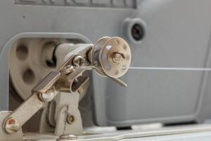 Details of a sewing machine, spool of thread photo